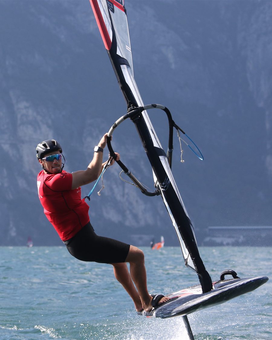 Noah foiling fast on Lake Garda with the mountains behind him