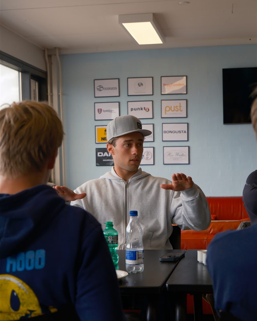 Noah explaining a technique to riders around a table at a camp