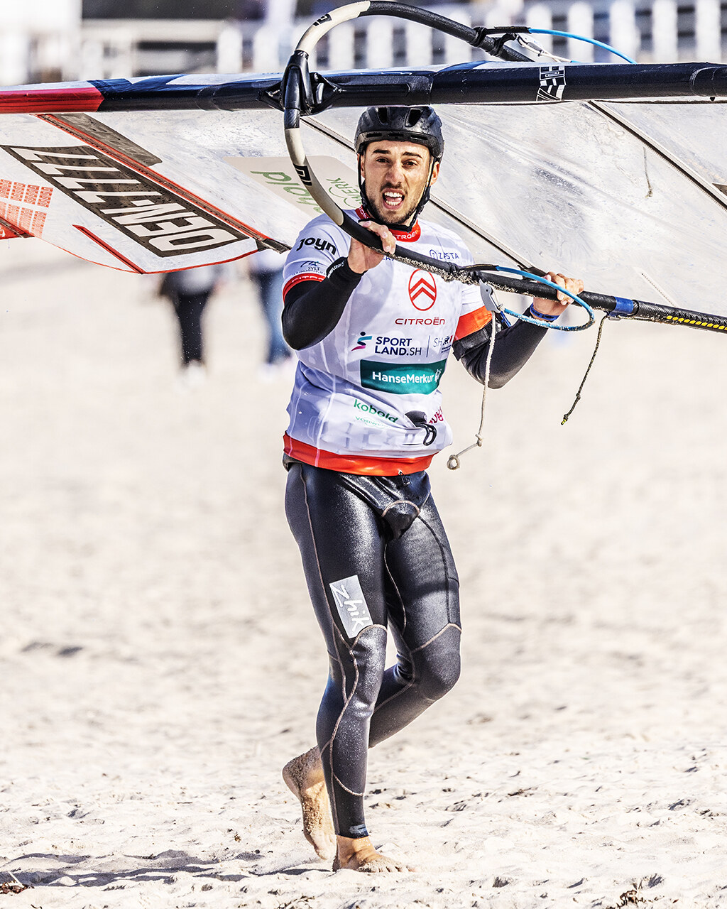 Noah at the PWA World Cup on Sylt, walking up the beach with his sail